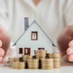 Mani intorno al modello di una casa