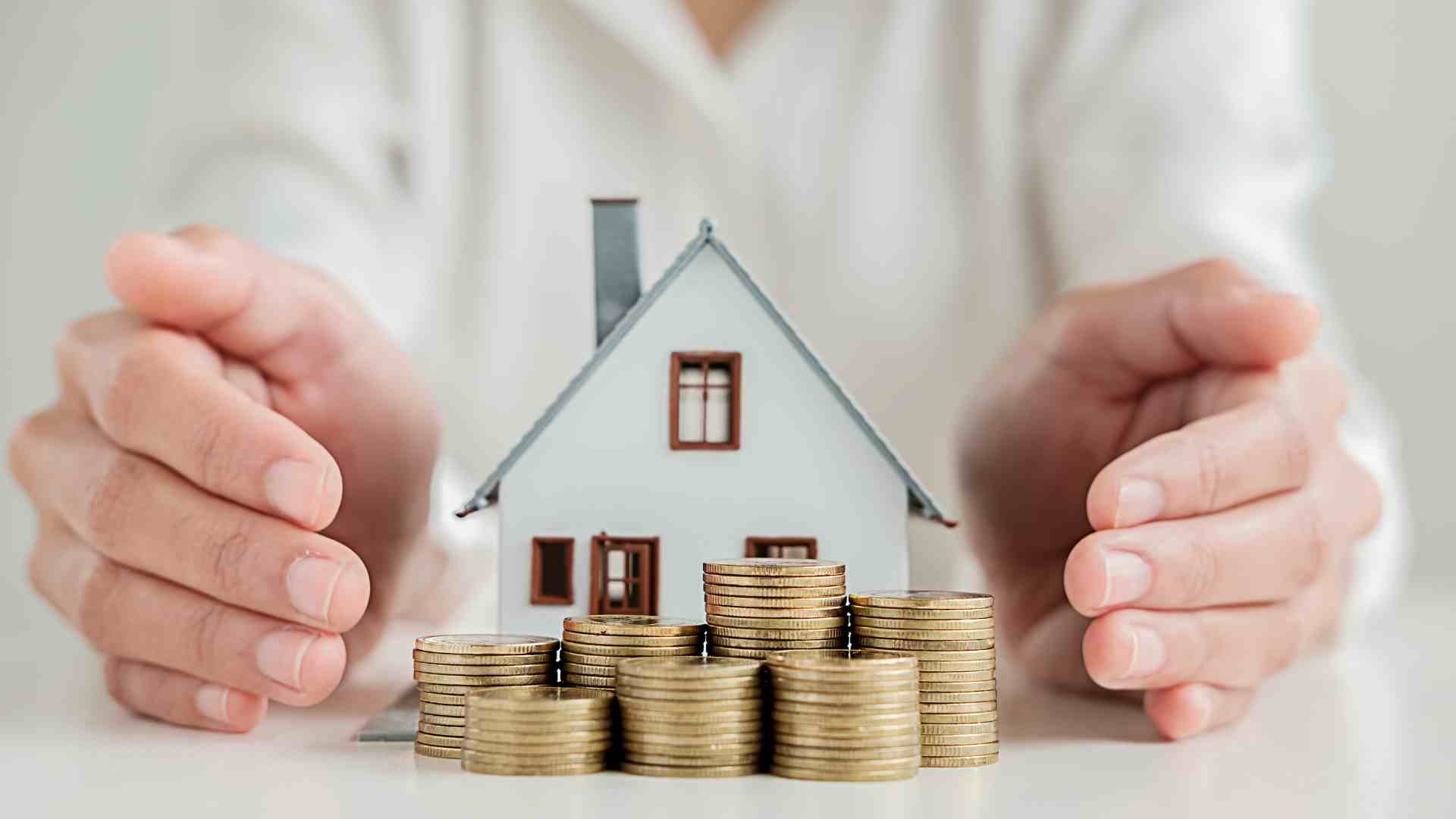 Mani intorno al modello di una casa